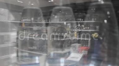 一家商店橱窗里的玻璃杯里有酒精的模糊反射。